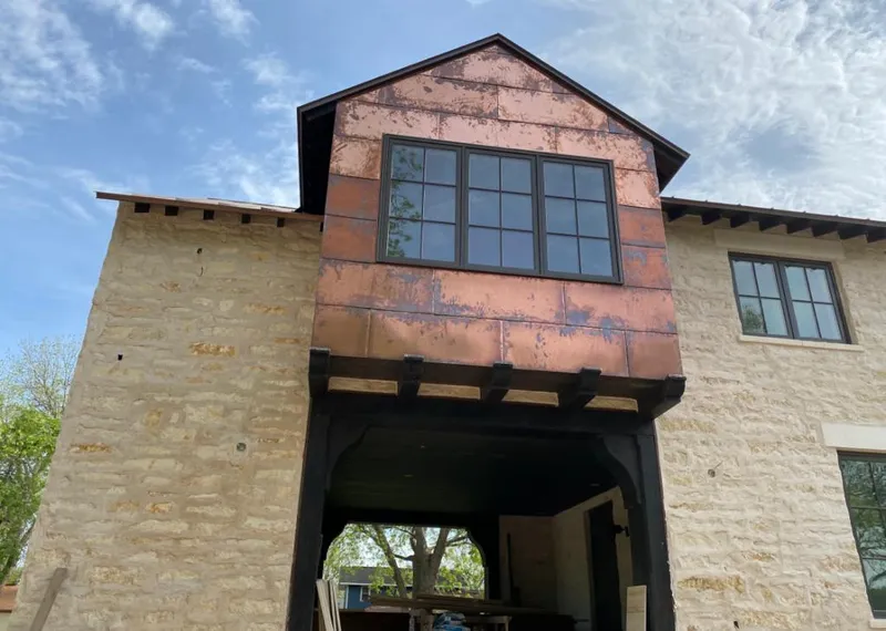 Copper metal panel facade on a stone building for Roof Repair in Ionia